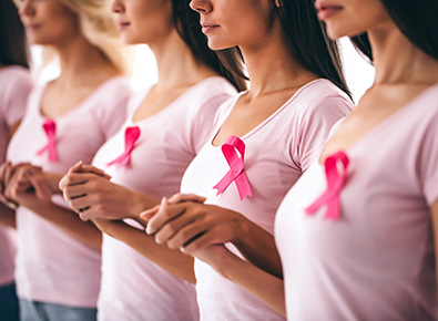 Photo of women dressed in pink t-shirts with cancer ribbons.